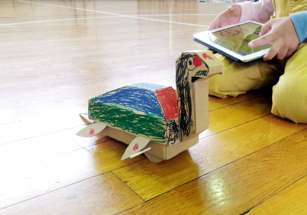 愛知工業大学と協力し、子供たち向けのイベントで使用する「段ボールで作れる首長竜」を提供しました。