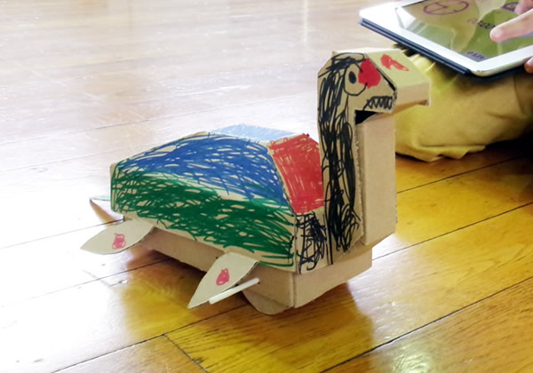 愛知工業大学と協力し、子供たち向けのイベントで使用する「段ボールで作れる首長竜」を提供しました。